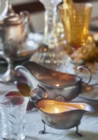 Silver gravy boat candle holder on dining table