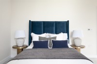 Bed with blue velvet headboard in modern bedroom