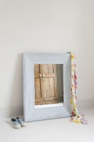 Distressed framed mirror leaning against a wall
