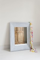 Distressed framed mirror leaning against a wall