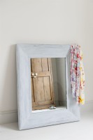 Distressed framed mirror leaning against a wall