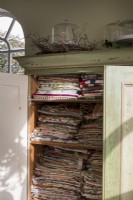 Linen cupboard packed with vintage materials and textiles