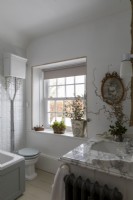 Traditional country cottage bathroom decorated for winter with vases of winter interest.