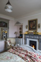 Cosy country bedroom at christmas, with fireplace and french style bed