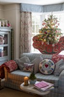 Sitting room with comfortable sofa and floral curtains, decorated for christmas