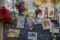 Notice board in kitchen with christmas cards, seed packets and fairy lights