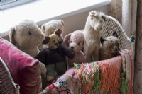 Collection of old stuffed toys in country bedroom