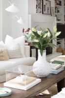 White vase and flowers on wooden coffee table