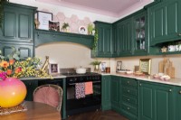 Kitchen with range and green painted cabinets