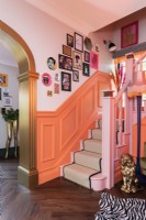 Colourful hallway and stairs with salon style art display