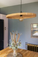 Pendant lamp with wicker shade hanging over a kitchen worktop