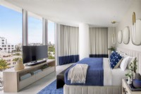 Modern blue and white bedroom with city view