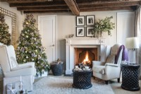 Lit fireplace in cosy country living room decorated for Christmas