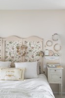 Floral screen as headboard in country bedroom 