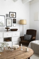 Brown armchair in corner of white painted country living room