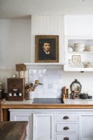 Old portrait painting on shelf in white country kitchen