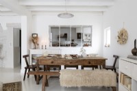 White country dining room with view of kitchen through internal windows