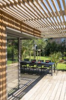 Shaded dining area on decking with view to garden beyond