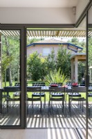 View through patio doors to outdoor dining table on decked terrace