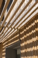 Detail of slatted wooden awning on modern timber clad house