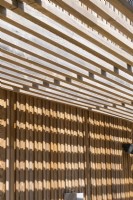 Detail of slatted wooden awning outside modern wooden timber house