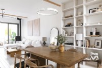 White painted modern open plan living space with wooden dining table