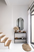 Modern black console table and mirror in white painted hallway