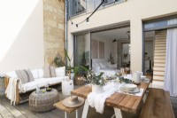 Outdoor living and dining area on small terrace with view into house