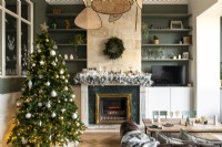 Christmas tree and lit fireplace in living room