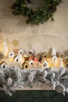 Display of tiny houses on mantelpiece for Christmas