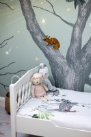 Detail of childrens bedroom with mural painted on wall
