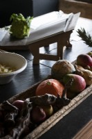 Wooden tray of fruit and vegetables on country kitchen worktop