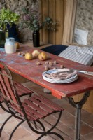 Detail of distressed red wooden outdoor dining table on terrace