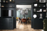 View into modern dining room thorugh black painted doorway