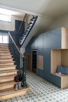 Modern built-in cabinets in hallway next to classic staircase