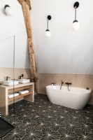 Modern bathroom with patterned flooring and exposed wooden beams