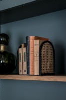 Books on shelf against dark grey painted wall