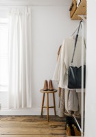 Open closet in a minimalist, contemporary bedroom.