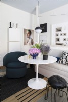 Modern round white pedestal dining table and seating.