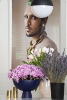 Display of flowers in vases with large photograph of man in background.