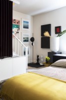 Modern bedroom with display of artwork on walls.