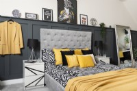 A monochrome and yellow bedroom with grey panelling

