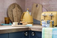 Detail of kitchen corner and worktop with kettle, toaster and chopping boards
