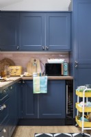 Blue painted kitchen units with pink tiles