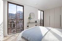 Modern bedroom with floor to ceiling sliding windows and Juliet balconies