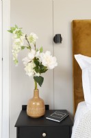 Bedside table with vase of flowers