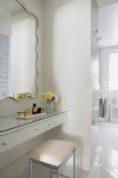 Vanity table, mirror and stool in modern white bathroom