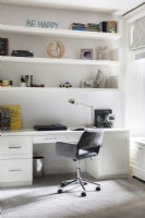 Modern white desk with shelves and grey desk chair.