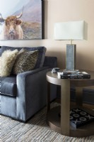 Details of side table and sofa with photograph of cow on wall.