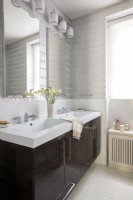 Modern white tiled bathroom with double sinks.